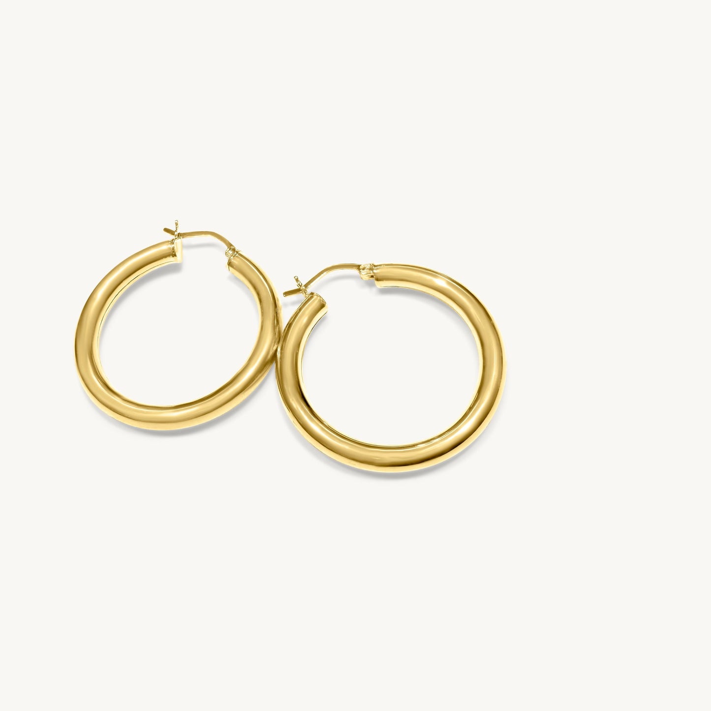 Hoop earrings became representative of the 1960s, complementing the prevalent trend of sleek, straight hairstyles during that era. These earrings are made of 14-karat solid yellow gold. The average weight of the hoop earrings is 6.2 grams. The thickness of the tube is 4 millimeters. The outer diameter of each hoop earring is 32.2 millimeters.