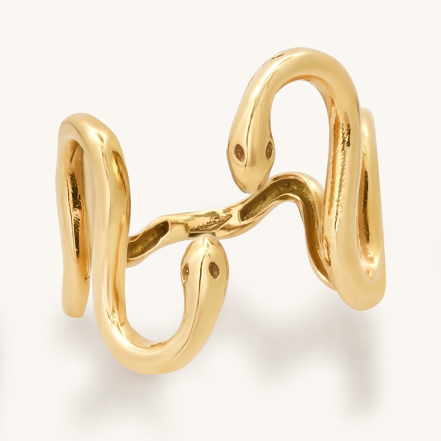 This exquisite gold snake ring, a testament to elegance and style, draws inspiration from the unique personality of my dear friend Cynthia. Crafted with meticulous detail, the coiled serpent design gracefully wraps around the finger, reflecting both sophistication and the spirit of friendship. This photo shows a front view of the snake ring highlighting how the two snake heads meet.