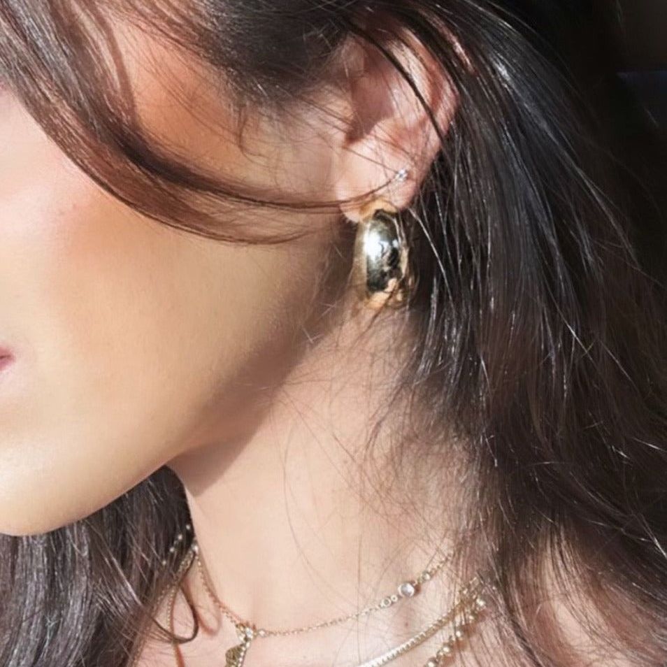 This photo displays our brunette model’s side profile and wearing the duomo earrings.